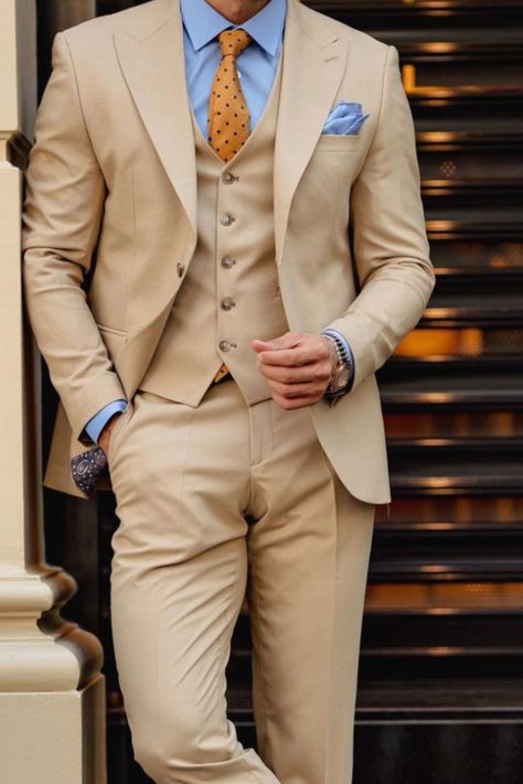 This is a tan three piece suit paired with a an orange patterned tie and baby blue shirt to make for an incredibly simply yet chic outfit. Beige Suit Blue Shirt, Beige Three Piece Suit Men, Tan Suit Blue Shirt, Tan And Blue Suit, Tan Suits For Men, Tan Suit Men, Three Piece Suit Mens Wedding, Mens Three Piece Suit, Beige Suits For Men