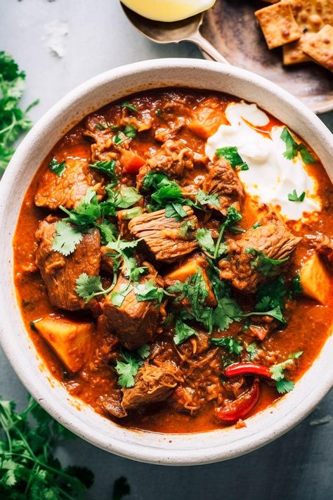 "Indulge in this Indian-style lamb curry, my delicious take on Rogan Josh with tender lamb in a rich, tomato sauce, spiced just right. It's the perfect comfort food, flavourful but not too spicy, with options to add more spice if you like. This easy curry only takes 20 minutes to prep and can be made either in a slow cooker or on the stovetop. It's a must-try for a cozy, satisfying meal. While this curry is not a traditional rogan josh, in that I use coconut milk and soy sauce for a Indian Lamb Curry, Lamb Curry Recipes, Slow Cooker Curry, Homemade Naan Bread, Pork Curry, Rogan Josh, Easy Curry, Slow Cooked Lamb, Lamb Curry