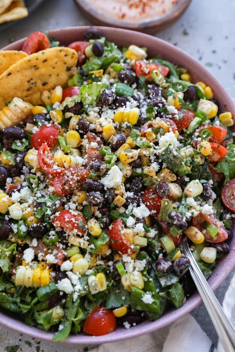 Crisp fresh lettuce, black beans, juicy tomatoes, sweet corn & green onion all tossed in a creamy homemade taco dressing & sprinkled with cotija cheese! This Mexican chopped salad is the perfect side dish for all your favorite Mexican recipes! Taco Dressing, Mexican Chopped Salad, Mexican Salad Recipes, Mexican Salads, Chopped Salad Recipes, Potluck Dishes, Cotija Cheese, Juicy Tomatoes, Green Onion