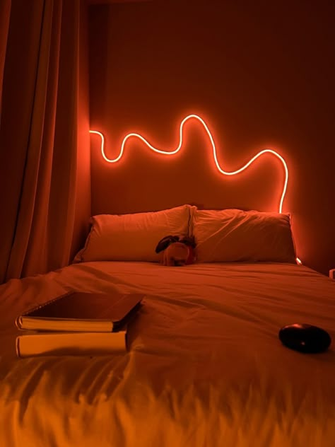 View of bed in bedroom with neon led rope light on orange Rope Lights Bedroom Ideas, Bedroom Rope Lighting Ideas, Squiggly Led Light On Wall, Rope Light Bedroom, Led Rope Lights Bedroom, Neon Rope Light Ideas, Led Rope Lighting Ideas, Rope Light Design, Rope Lights Bedroom