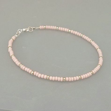 "This baby pink seed bead anklet has been lovingly made using glass 3mm opaque pink Preciosa seed beads.  Highlighted with 3mm Miyuki seed beads in a choice of silver or gold. Threaded on strong stainless steel 7 strand Tiger Tail wire and finished with silver/gold plated wire guardians and a lobster clasp, making it easy to put on & take off. With an optional 2\" Silver/gold plated extender chain so you can wear the anklet to sit where you feel most comfortable. I make these in various sizes in Pink Beaded Anklet, Cute Seed Bead Bracelets, Pink Seed Bead Bracelet, Seed Bead Anklet, Anklets Diy, Small Bead Bracelet, Pink Beaded Bracelets, Tiger Tail, Bead Anklet