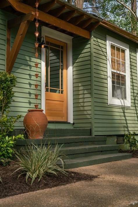 70s Exterior House Colors, Green Wooden House, Colorful House Exteriors, Light Orange House Exterior, Lime Green House Exterior, Earthy Green House Exterior, Green House Paint Ideas, Green House Orange Door, Front House Colors Ideas