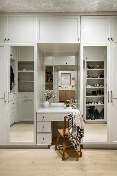 Custom walk in closet with mirrored wardrobe doors features a built in makeup vanity with vintage wooden chair and built in shoe shelves. Closet With Vanity Built In, Lhk Interiors, Walk In Closet Vanity, Closet With Vanity, Marble Herringbone Floor, Mirrored Wardrobe Doors, Closet Transformation, Built In Vanity, Blue Laundry Rooms