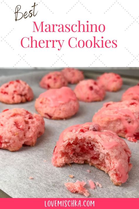 Pink cherry cookies on parchment paper. The closest one has a bite taken out of it to reveal bright red pieces of maraschino cherry and a moist, soft center. Cheery Cherry Cookies, Cherry Wedding Cookies, Cherry Maraschino Cookies, Recipes Using Cherry Juice, Maraschino Cherry Shortbread Christmas Cookies!, What To Do With Maraschino Cherry Juice, Cherry Cake Cookies, Cherry Bell Cookies, Italian Cherry Cookies Recipes