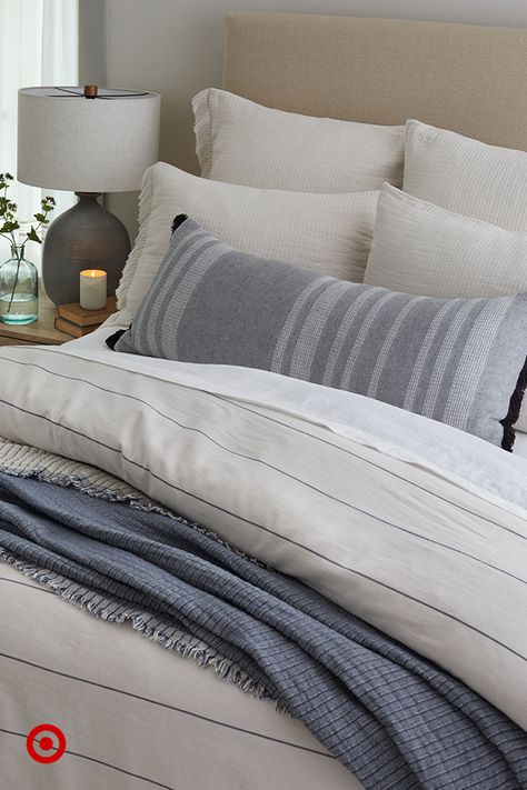 Create your own retreat with a mix of bedding in soft textures and simple patterns. Add pillows and a throw to finish the cozy look. #HearthAndHand Cream And Navy Bedding, Target Master Bedding, White And Navy Bedroom Ideas, Neutral Bedding With Blue Accents, King Size Bed Comforters, King Bedding Ideas, Blue Bedding Ideas, Warm Lighting Bedroom, Chambray Bedding