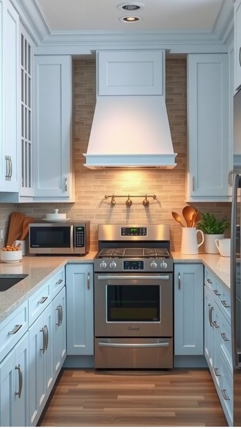 Modern kitchen with light blue cabinets, stainless steel appliances, and brick backsplash. Light Blue Kitchen Ideas, Blue And Grey Kitchen, Light Blue Kitchen Cabinets, Light Blue Backsplash, Blue Window Treatments, Contemporary Kitchen Lighting, Kitchen 2025, Blue Kitchen Ideas, Light Blue Kitchen