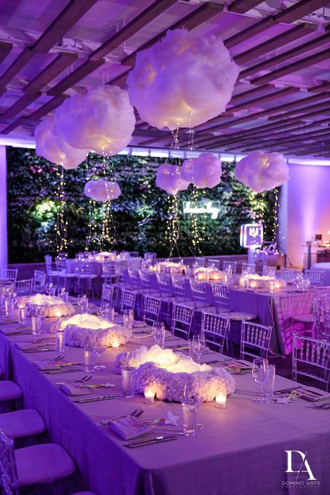 Ofir Creative executed this modern “Dream Big'' Bat Mitzvah perfectly. The celebration featured bright purple uplighting throughout the ballroom, chic lounge areas, and tables dressed in lush white florals with unique hanging cloud balloons and lights. Guests enjoyed an elaborate candy buffet before dancing the night away to live entertainment. Cloud Balloons, Purple Uplighting, Lavender Sunset, Hanging Cloud, Outdoor Rehearsal Dinner, Bat Mitzvah Themes, Hanging Clouds, Baby Shower Venues, Mitzvah Themes