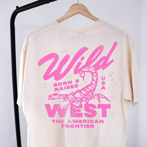 🤠Embrace the spirit of the Wild West with our "Wild West Born & Raised" graphic tee! This vintage-inspired shirt features a bold pink design that pays homage to the rugged American frontier. Perfect for your country concert or your night out in Nashville! 🔥 Stand Out in Style: Whether you're hitting the rodeo or just hanging out with friends, this graphic tee is sure to turn heads and start conversations. Pair it with your favorite jeans or shorts for a casual yet cool look that's perfect for any occasion.  🖤SHIRT MATERIAL Comfort Colors Unisex Shirt 100% Ring-Spun Cotton Printed using Direct To Garment style- Inks are printed directly into the fabric. Different sizing may effect placement of final design. Colors may differ slightly due to different user monitor and screen settings.  🏁 Country Concert Tshirts, Retro Graphic Shirt, One Color T Shirt Designs, Direct To Garment Printing, Western Shirt Vintage, Wild West Shirt, Concert T Shirt Design, Conference Shirt Design, Concert Tee Design