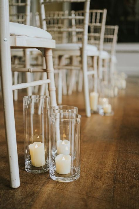 Fake white pillar candles sitting on hurricane vases for the aisle decoration Wedding Aisle Candles, Aisle Flowers Wedding, Backdrop Wedding Ceremony, Aisle Decorations Wedding, Aisle Decor Wedding, Aisle Candles, Flowers Wedding Ceremony, Wedding Aisle Decor, Wedding Altar