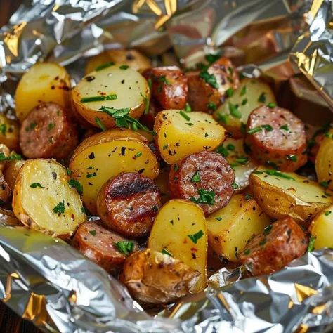 Sausage & Potato Foil Packet is a delicious and easy-to-make meal that perfectly combines savory sausages with tender potatoes and flavorful seasonings. This dish is not only satisfying and comforting, but it also has a versatile history that can be traced back to various culinary traditions around the world. From campfire cooking to backyard barbecues, this recipe has become a favorite among food enthusiasts due to its simplicity and fantastic flavors. This dish pairs wonderfully well with a si Foil Packet Dinners Oven, Hobo Packets In Oven, Sausage Foil Packets For The Oven, Sausage And Potato Foil Packets, Sukkot Meals, Hobo Packets, Hobo Packs, Kielbasa And Potatoes, Cheesy Baked Chicken