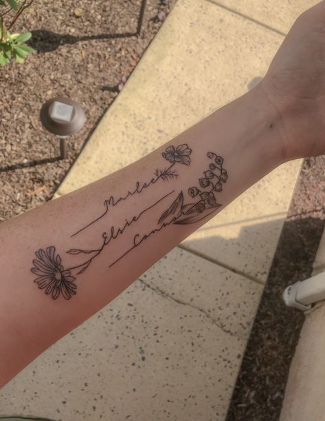 This tattoo was created for my 3 kiddos! Each child’s name goes with each of their birth month flowers. Cosmos for October, daisy for April, and lily of the valley for May. Tato Nama, Name Flower Tattoo, Cosmos Tattoo, Daisy Tattoo Designs, Kid Name Tattoo, Flower Tattoo Ideas, Tattoos With Kids Names, Daisy Tattoo, 4 Tattoo