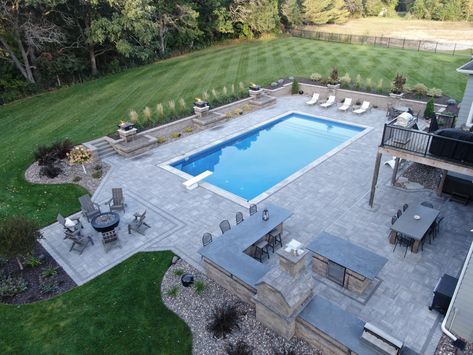 Check out our extensive outdoor entertainment space. Here is what we did:

- Installed a new underground pool
- Added an outdoor gas firepit
- Built a new outdoor kitchen with pizza oven, grill, and island
- Created multiple large paver patio areas
- Added paver walls and fire bowls around pool
- Installed new plants, edging, rock, and mulch Pool Fire Pit Outdoor Kitchen, Backyard Pool And Grill Ideas, Pool Patio Paver Ideas, Backyard Oasis With Inground Pool, Pool Patio Fire Pit, Pools Backyard Inground Rectangle, Rectangle Pools With Spa, Outdoor Kitchen By Pool Ideas, Patio With Pool Ideas Backyard Designs