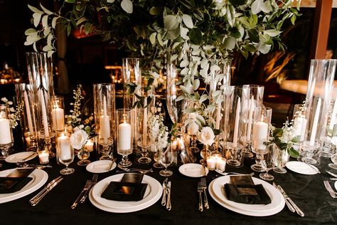 Reception tables were covered with black linens and decorated with high and low arrangements of white flowers with ample greenery, illuminated with candlelight… White And Gold Wedding Table, Black Wedding Reception Decor, Wedding Table Black, Poolside Wedding Ceremony, Black Tablecloth Wedding, Black Wedding Table Setting, Black Wedding Reception, Black Wedding Table, Black White And Gold Wedding