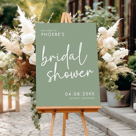 [PaidLink] Make A Stylish And Chic First Impression With This Sage Minimalist Script Bridal Shower Welcome Sign. This Modern Bridal Shower Decor Features A Simple Yet Elegant Minimalist Script Font That Effortlessly Sets The Tone For A Sophisticated Soiree. With Its Minimalist Script Font And Calming Sage Green Color, This Sign Is Perfect For The Modern Bride Who Wants Her Bridal Shower Decor To Feel Chic And Refined. Hang This Beautiful Welcome Sign To #simpleneutralbridalshowerdecor Bridal Shower Ideas Plant Themed, Sage Green Boho Bridal Shower Ideas, Bridal Shower Decorations Green, Wedding Shower Decor Ideas, Sage And Gold Bridal Shower Ideas, Bridal Shower Ideas Sage Green, Green And White Bridal Shower Decor, Emerald Green Bridal Shower Ideas, Green Bridal Shower Theme