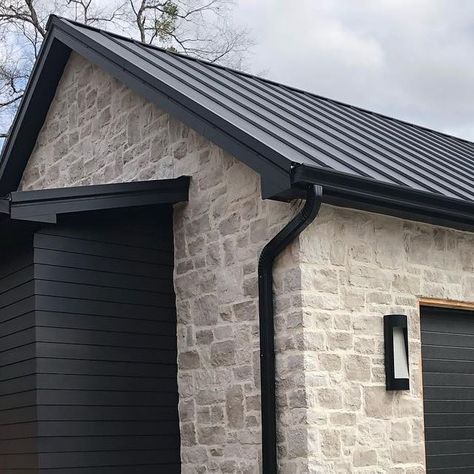 Stone House Metal Roof, Stone Garage Exterior, Black And Stone Exterior, Stucco And Board And Batten Exterior, Over Grouted Stone Exterior, Black Stucco House Exterior, Black Vertical Siding, Black And Stone House Exterior, Exterior Stone Ideas