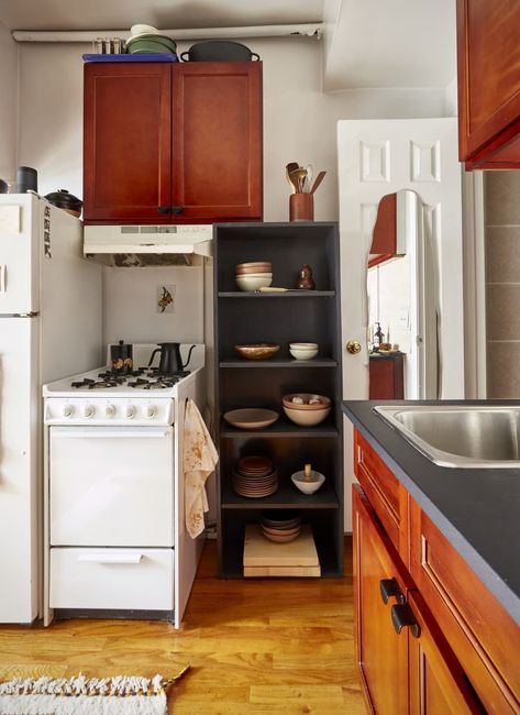 Small studio apartment kitchen corner with black storage shelf and petite stove Best Kitchen Storage, Nyc Studio Apartments, Simple Bookshelf, Tiny Studio Apartments, Furniture Apartment, Linen Bed Cover, Apartment In New York, Kitchen Addition, Nyc Studio