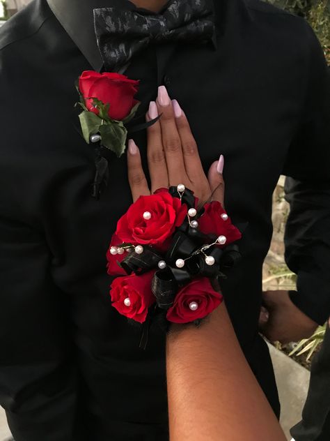 Red roses, all black ribbons with white pearls Red Black Corsage, Red And Black Prom Corsage, Black And Red Prom Flowers, Black And Red Boutonniere, Red Flower Corsage, Red Rose Corsage And Boutonniere, Red And Black Corsage And Boutonniere, Prom Corsage And Boutonniere Red, Corsage Prom Red