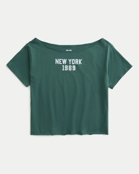 Details  Easy Off-the-Shoulder New York Graphic Tee  A super soft tee featuring an off-the-shoulder neckline and New York print graphics. Short sleeves. Easy Fit. Imported.  Store Item: 357-294-00151-300  Web Item: 602247/357-4070-00151-300 Graphic Shirts Aesthetic, Off The Shoulder Graphic Tee, My Wishlist Ideas, Cute Shirts Aesthetic, Fake Clothes, Hollister Clothes, Los Angeles Graphic, New York Graphic, Off The Shoulder Tee