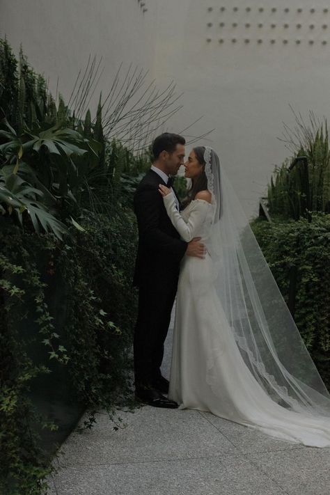 Bride wears a classic off the shoulder gown with a scalloped cathedral length veil, looking up at her groom, wearing a black tuxedo Mexican Bridal Veil, Simple Wedding Dress With Veil Lace, Super Long Veil Wedding, Sheath Wedding Dress With Veil, Mantilla Veil Hair Down, Wedding Veils Covering Face, Italian Bride Traditional, Spanish Style Veil, Mexican Wedding Veil