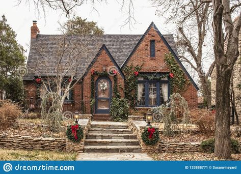 Photo about Cute brick cottage with red bows and greenery - decorated for Christmas in bleak wintertime. Image of exterior, garland, decorations - 133888771 Iron Front Doors, Wrought Iron Front Door, Brick Cottage, Tudor Style Homes, Cottage Exterior, Brick Exterior House, Tudor House, Dream Cottage, Cute House