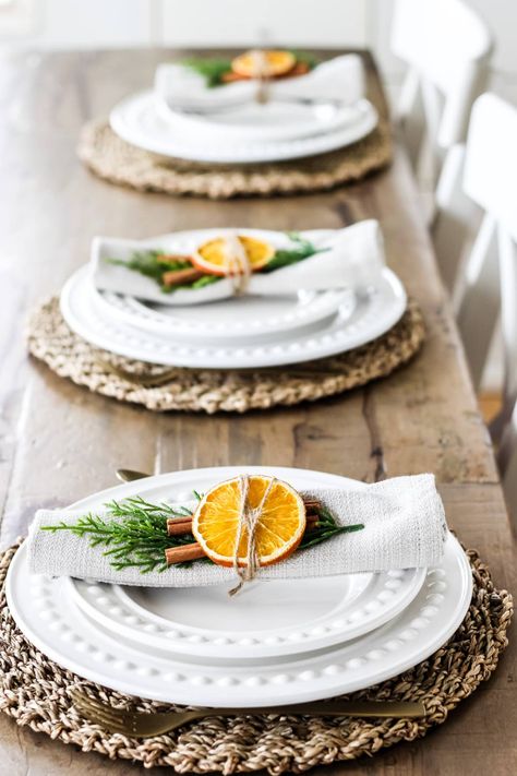 These DIY Orange and Cinnamon Stick Napkin Rings make a beautiful natural addition to your holiday table. Make your own in just minutes with simple and inexpensive supplies. Orange Napkin Table Setting, Christmas Table Settings Natural, Pennygum Table Decor, Natural Christmas Dining Table Decor, Cinnamon Stick Napkin Ring, Christmas Table Decorations Minimalist, Thanks Giving Table Decorations Diy, Table Decor With Oranges, Christmas Natural Table Settings