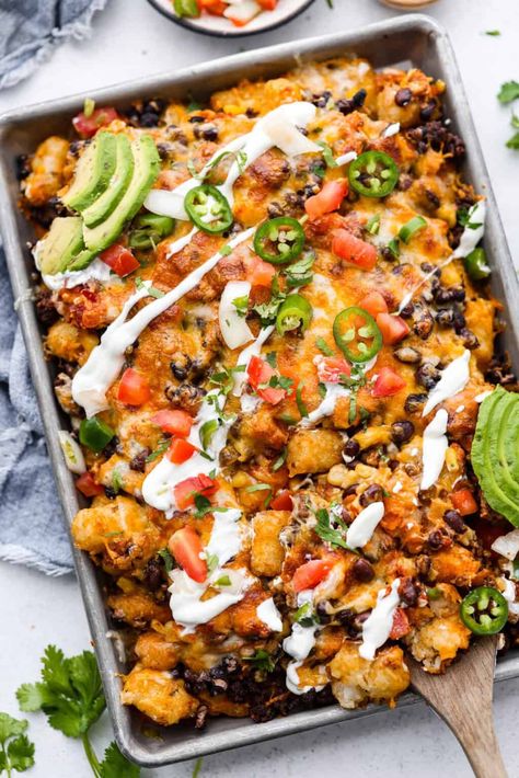 Tater Tot Nachos (Totchos) are made with crispy golden tater tots, topped with seasoned beef, scoops of refried beans, corn, black beans, salsa and melty cheese. Add your favorite toppings and dig in! Tator Tot Recipe, Baked Caprese, Totchos Recipe, Nacho Casserole, Tot Nachos, Baked Caprese Chicken, Nacho Recipes, Tater Tot Nachos, Nacho Recipe