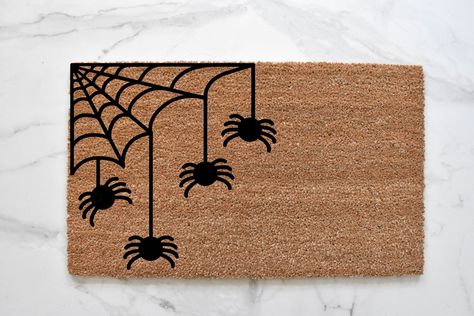 SPIDER WEB DOORMAT Welcome to our web. Our spider welcome mat is the perfect way to create a cute and spooky Halloween entryway. Front door mats make perfect wedding, housewarming, and birthday gifts!MATERIAL: natural coir front with a durable vinyl backingSIZES: 18" x 30" and 1/2 inch thick CARE: shake or vacuum to clean and refreshDESIGN: hand-painted with durable outdoor all-weather paint This hand-painted doormat is the perfect decorative accent to any entryway! Made with 100% coir, which ar Spider Web Door Mat, Halloween Door Mat Ideas Diy, Sip And Paint Halloween Door Mat, Spooky Rugs Diy, Door Mat Painting Diy Halloween, Halloween Door Mat Party, Painting Door Mats Diy Halloween, Doormat Ideas Halloween, Halloween Door Mat Painting