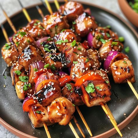 Teriyaki Chicken Skewers 🍢 Ingredients : 🍗 500g chicken breasts 🌾 3 tablespoons of soy sauce 🍯 2 tablespoons of honey 2 cloves of garlic, minced 1 red onion, diced 🍍 1 red pepper, diced 🍚 2 tablespoons of sesame oil 🍡 Wooden skewers (soaked in water) 🌱 Sesame seeds (for garnish) 🌿 Fresh coriander (for garnish) Instructions : 1️⃣ Cut the chicken breasts into cubes of uniform size and place them in a bowl. 2️⃣ In another bowl, mix the soy sauce, honey, minced garlic and sesame oil to prep... Chicken Skewers And Rice, Teriyaki Chicken Skewers, Wooden Skewers, Food Babe, Chicken Skewers, Exotic Food, Coriander Leaves, Teriyaki Chicken, Chicken Nuggets