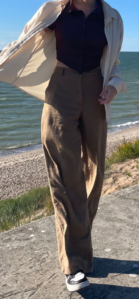 Woman standing by the sea. windy, flowy clothing, beige colors. Asymmetric corset top, wide-end pants. Blue/ brown color palette/light setting Dark Academia Outfit Inspo Summer, Dark Academia 90s Aesthetic, Summer Fits Dark Academia, Dark Academia Travel Outfits, Summer Outfit Academia, Old Clothing Aesthetic, Summer Outfits Light Academia, Outfit Ideas Old School, Dark Academia Fits Summer