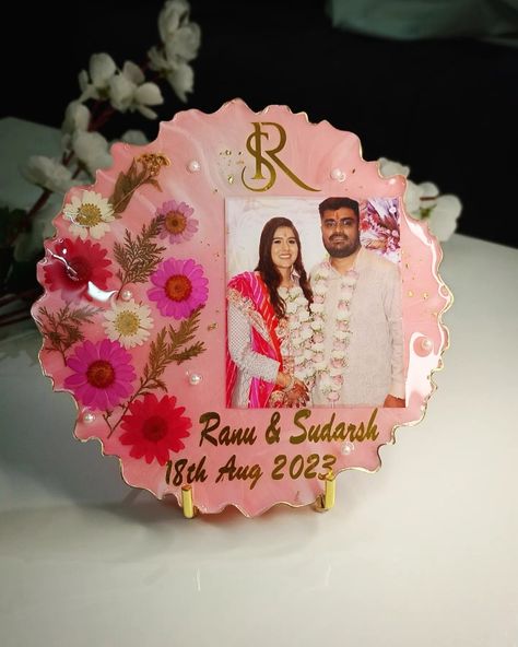 Resin couple photo frame preserving daisy flowers and containing name initials of SR and date of engagement with photo of engagement. Epoxy frame ideas, handmade gift ideas, handmade couple frame from resin, pink white colour frame , Name ranu and sudarsh, frame with fairy light or cork light on the back side and metal stand for holding the frame. Anniversary gift ideas, Birthday gift ideas, Wedding gift ideas, Resin art ideas, Resin things Epoxy Resin Photo Frame, Photo Frame Resin Art, Resin Photo Frame Ideas, Epoxy Frame, Couple Photo Frame, Frame Anniversary Gift, Cork Light, Couple Frame, Resin Photo Frame