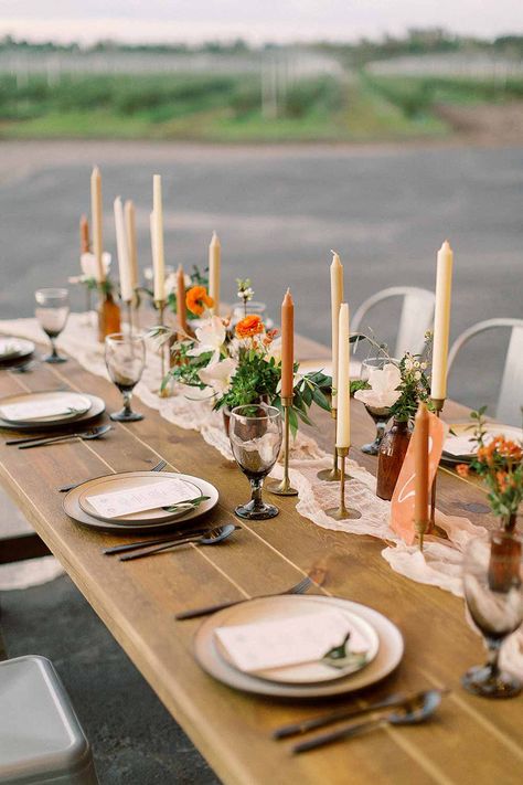 Mid Century Modern Farmhouse Wedding Inspiration Wedding garland tablescape with brass candlesticks. #weddinginpso #tablescape #weddingdecor #rusticwedding Diy Tablescapes Wedding, Farmhouse Long Table Decor, Candlestick Wedding Table, Diy Wedding Tablescapes, Diy Table Arrangements, Wooden Tablescape, Wedding Table Taper Candles, Wedding Candlestick Centerpieces, Minimalist Wedding Set Up