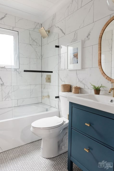 Modern coastal inspired bathroom renovation with marble tile, shiplap, gold and black accessories, clear shower door, blue and white colors & rattan accents Modern Coastal Bathroom, Coastal Bathroom Design, White Marble Bathrooms, Marble Tile Bathroom, Small Bathroom Renovation, Coastal Bathroom, Bad Inspiration, Accessories Ear, Coastal Bathrooms