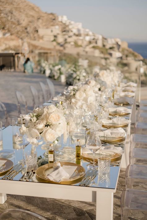 Curating an opulent and elegant affair in Mykonos! ✨ This luxurious wedding featured a grand dinner setup, with mirror-topped tables and an abundance of white blooms. Every detail exuded sophistication, creating a truly memorable celebration.💍 🥂 #luxurywedding #destinationwedding #LuxuryWeddingMykonos⁠ #greece #AegeanElegance#LuxuryByTheSea #ElegantEventDesign #IslandWedding #LoveInGreece #ChicFloralDecor ⁠ Luxury Coastal Wedding, Rocabella Santorini Wedding, Greece Wedding Theme, All White Beach Wedding, Seaside Wedding Decor, Beach Theme Wedding Reception, Wedding Turkey, Luxury Beach Wedding, Dinner Setup