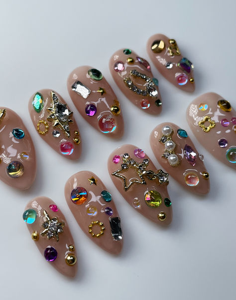 Nails with rhinestones all over, Nails with gems all over, Junk nails, Nude nails with gems, Maximal nail inspo, maximal nail art, rainbow gem nails, innerbloom nails 2025 Nail Art Trends, Charm Filled Nails, Gem Covered Nails, Gold Nail Charm Designs, Colorful Nails With Charms, Colorful Gem Nails, Jeweled Nails Designs, Nail Gems Designs, Gem Manicure