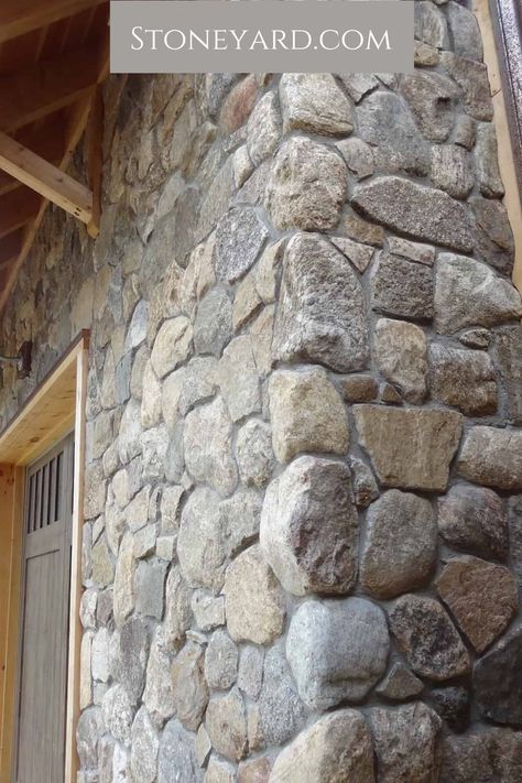 Our round stone veneer is the perfect product for your upscale home. Don't just trust us, look at this rustic stone and wood house exterior. Click here for more exterior ideas for your house. Stone On Foundation Of House, Faux Stone House Exterior, Wood And Stone Walls Interior Design, Field Stone Exterior House, River Stone Exterior Houses, Diy Stone Exterior House, Stone Veneer Chimney Exterior, Rock Wall House Exterior, Cobblestone Exterior House