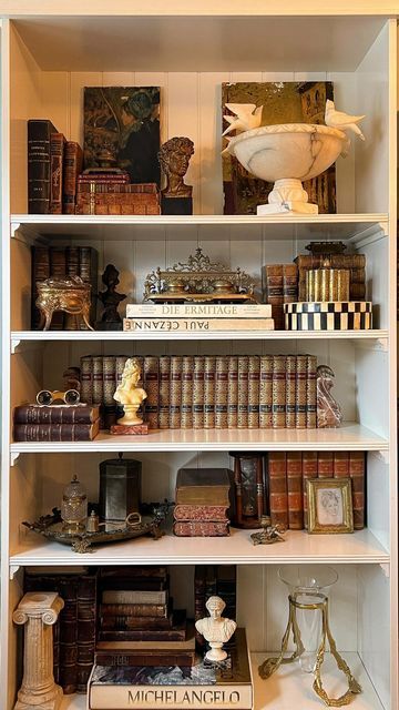 Antique & Vintage Home by Veronica Ashley on Instagram: "Style my vintage shelves with me ✨ It was time to transform my shelves back to a former version of themselves— with some updates, of course! Layering my own curated collection of vintage and antique treasures on these shelves gives me so much joy and I wanted to share that process with you. Stay tuned as I am back this week (and next) with lives sales lined up! So many more vintage and antique treasures to come. Follow along for more vintage and antique hauls, shop collections, live sales and more! ✨ Xx Veronica . . . . . #vintagedecor #shelfstyling #antiquelove #vintagehomedecor #onlinevintageshop #vintagehaul #shopvintage #curatedvintage #smallbusiness #vintageshop #antiquesofinstagram #estatesalefinds #thriftedandstyled #myc Bookshelf Ideas Vintage, Antique Shelf Decor Display, Decorating Shelves With Antiques, Victorian Shelf Decor, Vintage Bookcase Styling, Wall Bookcase Decor, How To Style Office Shelves, Bookshelves In Living Room Decor, Antique Shelves Display Ideas