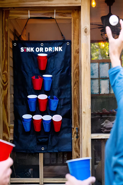 Portable beer pong game for door hanging fun. Play beer pong without a table. Sink or Drink is a beer pong game that hangs on the back of doors, and features sleeves to hold cups. Complete set includes 10 party starter cups, 2 pong balls, and door hangers. Hang it, play it, sink it. Explore our Pinterest Board for more ideas and in-depth details on Marmalade. #GameIdeas #HolidayPartyGames #PartyActivities #FestiveFun #BoardGames #CardGames #TriviaGames #DrinkingGames Friendsgiving Games, Pong Game, Classic Card Games, Reunion Games, Spirit Drink, Candy Games, Party Starters, Holiday Party Games, Beer Pong Tables