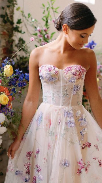 💐Floral Wedding Gowns💐  Which of these Hand-painted gowns is your favorite? A colorful wedding dress is the perfect focal point for a modern bride looking for some color for her wedding. Beautiful feminine shades of pink and purple! Wedding Dress With Colourful Flowers, Wedding Dress With Flowers On Skirt, Reception Dress Floral, Brides Party Dress, Floral Colorful Wedding Dress, Colourful Flower Wedding Dress, Bright Floral Wedding Dress, Colorful Bridal Dress, Unique Wedding Dresses Floral