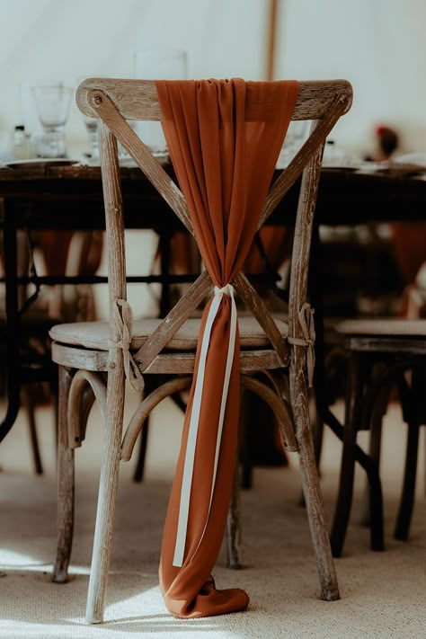 Burnt orange sheer material tied with white ribbon decorating the wooden chairs Wooden Chair Wedding Decor, Rust Chair Sash, Terracotta Chair Sash, Boho Wedding Chair Decor, Boho Chair Decor, Orange Chair Decor, Burnt Orange Wedding Ceremony, Wooden Wedding Chairs, Partridge Photography