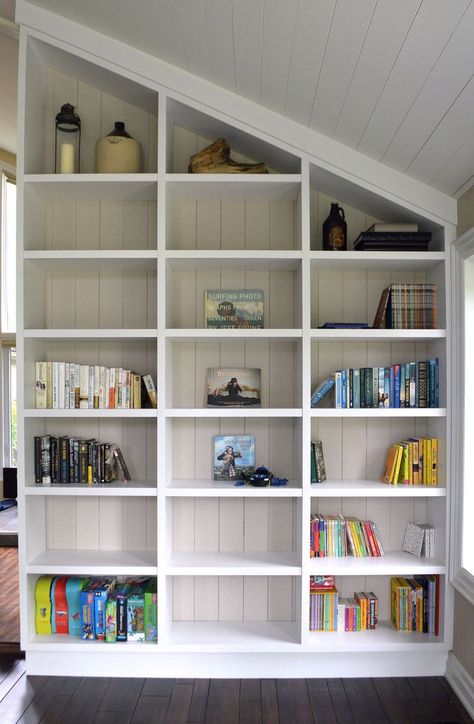 One of a Kind Custom white open shelving unit, built to fit in angled ceiling Bookshelf Angled Ceiling, Built In Bookshelf Sloped Ceiling, Angled Ceiling Bookshelves, Shelves On Angled Wall, Angled Ceiling Shelving, Slanted Wall Library, Angled Wall Built In, Built In Shelves On Slanted Wall, Angled Ceiling Built In Bookshelves