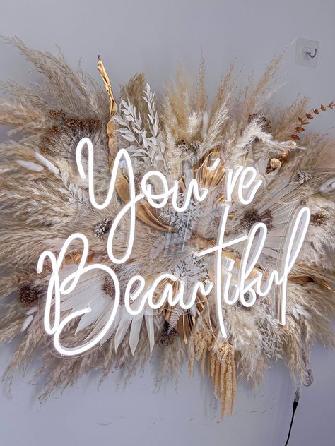 #WeddingNeonSigns #WeddingDecor #CustomNeonSigns #UniqueLighting Salon Lights Ideas, Pampas Grass Wall Decor With Neon Sign, Pampas Grass Decor Wall, Beige Salon Decor, Boho Beauty Room, Salon Flower Decor, Boho Salon Suite Decor, Pampas Sign, Boho Hair Salon Decor