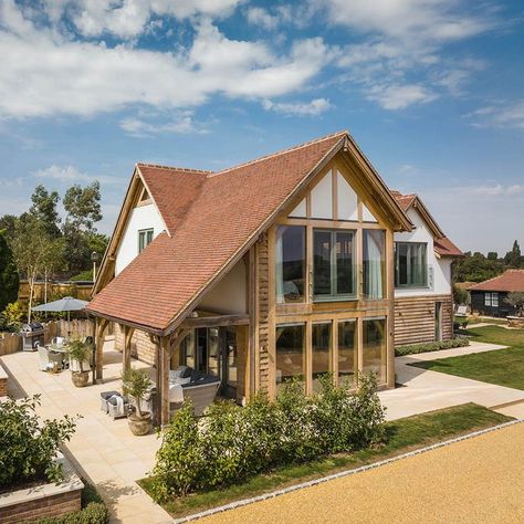 Oakwrights design and build bespoke oak framed buildings, including oak frame houses, oak frame garage and oak frame extensions. Beautiful shot of the exterior of this barn style oak frame house with juliet balcony and stunning face glazing. A fantastic self build project we have recently completed with our clients. #julietbalcony #countryliving #faceglazing Follow the link to read more about their self build journey. Oakwrights Houses, Two Storey Extension, Oak Frame House Exterior, Oak And Glass Extension, Oak Framed Extension On Bungalow, Two Storey Oak Frame Extension, Welsh Oak Frame House, Timber Frame Extension, Oak Framed Extensions