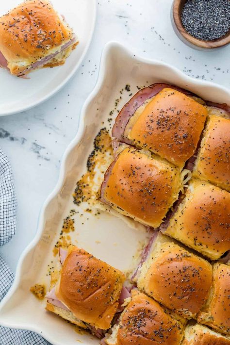 Funeral Sandwiches are delicious ham and cheese sliders you can make as an easy appetizer recipe or as a family friendly meal. Full of warm salty ham, nutty Swiss cheese and topped with a tangy Dijon butter sauce, these mini slider sandwiches are nothing to be sad about! Overnight Ham And Cheese Sliders, Ham Biscuits With Poppy Seeds, Little Hammies Sandwiches, Sauce For Ham Sandwiches, Ham Poppyseed Sliders Hawaiian Rolls, Mini Ham And Cheese Sliders, Turkey Ham Sliders, Hot Ham And Cheese Sandwiches Baked, Warm Sandwich Recipes