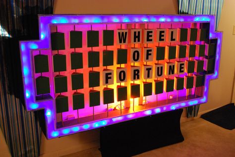 https://flic.kr/p/6dXn2s | Wheel of Fortune Puzzle Board | Here is my take on the "Wheel of Fortune" puzzle board. The frame is made of 1/2" plywood with the outside wrapped in black carpeting. The border consists of 120 blue LED lights and covered by frosted Plexiglass. The backlight is an orange CFL bulb. The trilons (letterboxes) are foamboard suspended on wooden dowel rods. 91"W x 42.5"H x 12.5"D  *Note: The height is taken from the bottom of the board not the p Wheel Of Fortune Party, Game Show Party, Frosted Plexiglass, Wheel Of Fortune Game, Diy Yard Games, American Girl Doll House, Elderly Activities, Vbs 2023, Senior Activities