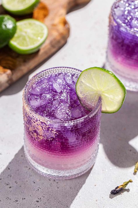 The Galaxy Margarita is as tasty as it is beautiful! Tequila that's naturally colored by butterfly pea flowers is layered on top of a Cointreau and lime base. Edible glitter takes it to the next level! It is a fun galactic spin on a classic margarita. This is the perfect margarita recipe for a girls night, bachelorette or just a night of stargazing! Ginger Shrub Recipe, Rhubarb Gin Cocktail, Summer Happy Hour, Perfect Margarita Recipe, Classic Tequila Cocktails, The Perfect Margarita, Shrub Recipe, Butterfly Pea Flowers, Simple Syrup Cocktails