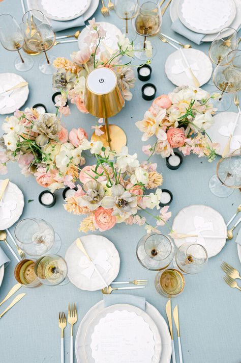 The table decorations for this wedding at Château de la Tour Vaucros were designed to echo the colors of Provence - soft eucalyptus blue, reminiscent of the leaves of olive trees, and peach, pink and coral, catching the light of the evening sun. The tables, grouped around a central floral installation, were set with linen tablecloths and gold cutlery - a tribute to the Mediterranean landscape and the flora of Provence. Mediterranean Table Setting, Mediterranean Table, South Of France Wedding, Wildflower Wedding Theme, Mediterranean Landscape, Mediterranean Wedding, Linen Tablecloths, Wedding In France, Provence Wedding