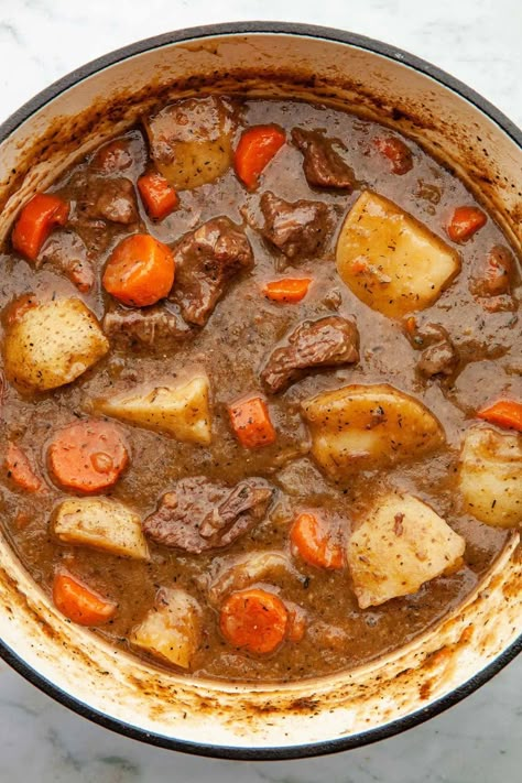 Dutch oven beef stew is a classic winter warmer. With tender beef, rich gravy, and hearty root vegetables, it's cold weather comfort food! Beef Stew In Dutch Oven, Stew In Dutch Oven, Beef Stew Recipe Oven, Canned Beef, Cooking Stew Beef, Dutch Oven Beef Stew, Oven Beef Stew, Dutch Oven Beef, Chicken Recipes Indian