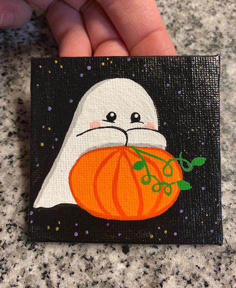 cute ghost on pumpkin, mini canvas painting. Hand drawn and painted on 2.5x2.5 canvas. Mini easel is included with painting. Each painting is made to order and may vary slightly. Sprayed with a glossy sealant. Mini Canvas Step By Step, Fall Art Painting Canvases, What To Paint On Tiny Canvas, Easy Painting Ideas For Pumpkins, Canvas Fall Ideas Painting, Halloween Ghost Painting Ideas, Ghost Holding Pumpkin Painting, Mini Canvas Halloween Art, Simple Cute Paintings On Canvas Easy Diy