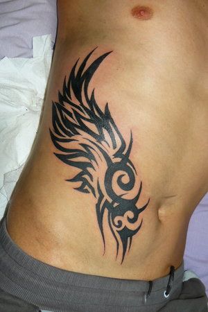 Rib Cage Tattoo Ideas for Guys Stammestattoo Designs, 21 Tattoo, Tattoo Colors, Rib Tattoos For Guys, Wing Tattoo Men, Ribcage Tattoo, Tattoo Ideas Easy, Wing Tattoo Designs, Wing Tattoo