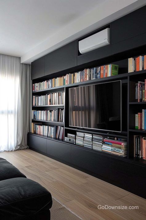 Black cabinetry and shelving create a sleek, modern look that can elevate the overall design of a room. Tv And Bookcase Wall, Tv Bookcase, Black Tv Unit, Basement Tv Rooms, Black Bookshelves, Black Cabinetry, Bookshelves With Tv, Staircase Interior Design, Under Tv